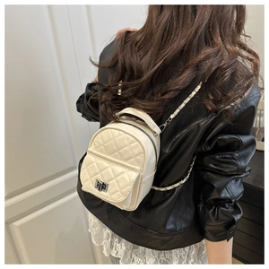 Detail of ivory quilted mini backpack with silver chain straps and metallic clasp