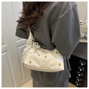 White cloud bag detail with lace bows, pearls and golden dog paw metal charms