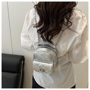 Zilveren mini-tas met ruitpatroon en kettingriem getoond op een model voor maat
