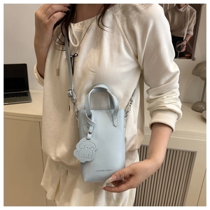 Détail du mini sac de téléphone bleu clair avec texte de mode et breloque chien