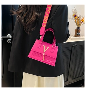 Detail of fuchsia quilted handbag with gold V-buckle and elegant tassel charm