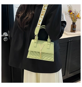 Detailed close-up of light green quilted leather bag with gold V-logo and tassel detail