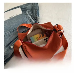 Top view of open oxford crossbody bag showing interior storage for phone and wallet