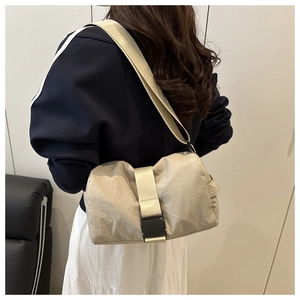 Model view of beige nylon crossbody bag with large capacity and durable buckle closure
