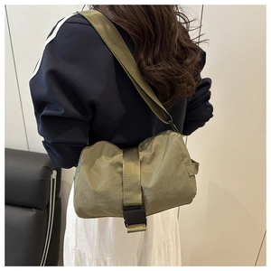 Olive green oxford fabric crossbody bag with wide strap and large buckle closure detail