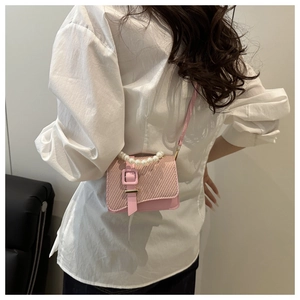 Pink PU leather crossbody bag with woven texture lid and elegant pearl handle detail