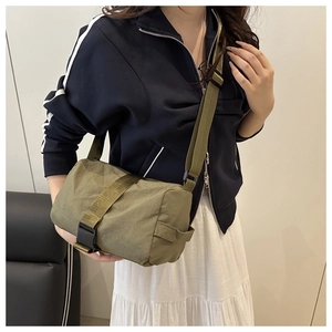 Close-up of olive green nylon crossbody bag with adjustable strap and black buckle closure