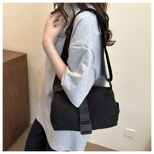 Détail de la besace noire en tissu Oxford avec boucle pratique et bandoulière réglable