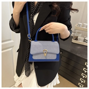 Detailed shot of blue textured patchwork shoulder bag with elegant gold metal buckle