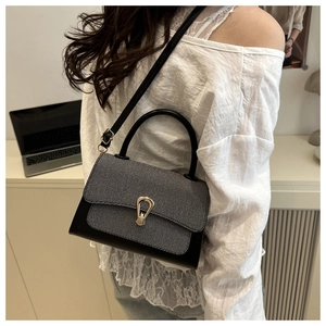 Model wearing a vintage tweed and black leather crossbody bag with a gold buckle clasp