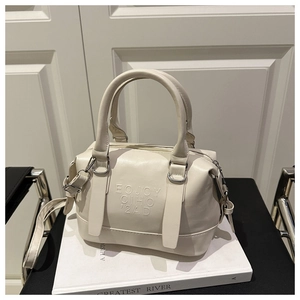 Détail d'un sac Boston blanc crème avec lettrage gaufré et fine bandoulière réglable