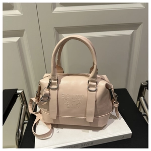 Vue détaillée des lettres embossées sur le sac Boston beige avec texture de cuir de qualité