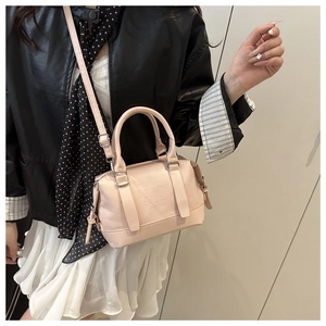Photo de style d'un sac à bandoulière rose pâle avec poignée et détail gaufré élégant