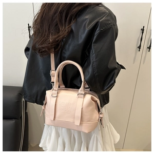 Vue détaillée du sac Boston en cuir rose avec lettrage embossé et garniture argentée