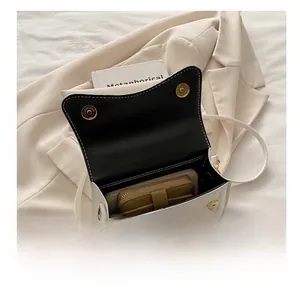Internal view showing capacity for a wallet and smartphone in this square crossbody bag