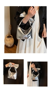 Detailed view of silver metallic handbag with oversized bow handle and half-moon design