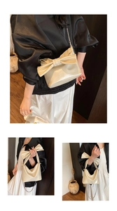 Detail showing creamy white bow tote bag with metallic chain strap and glossy finish