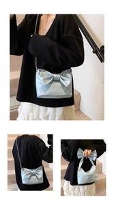 Close-up of a light blue bow shoulder bag featuring shiny patent leather and silver chain strap