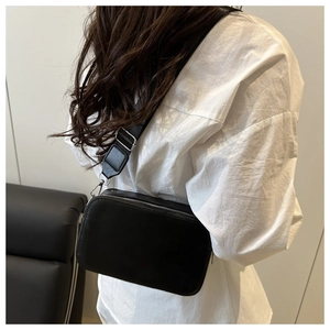 Detail showing high-quality lychee texture and silver double zippers on the black camera bag