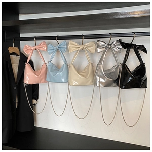 Close-up of five stylish bow handbags with silver chains in various vibrant colors