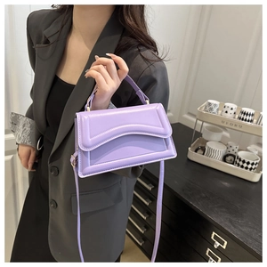 Detail view of purple crossbody bag with wave quilting and adjustable shoulder strap