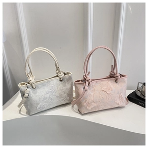 Détail de sacs cabas en dentelle avec papillons 3D en blanc et rose poudré délicat