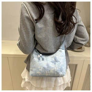 Close-up of light blue lace bucket bag with 3D butterflies and beaded drawstring detail