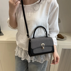 Minimalist black and grey crossbody bag with gold hardware shown in a modern lifestyle setting
