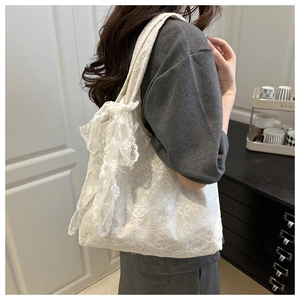 Detailed shot of white floral lace tote bag featuring a large decorative side bow