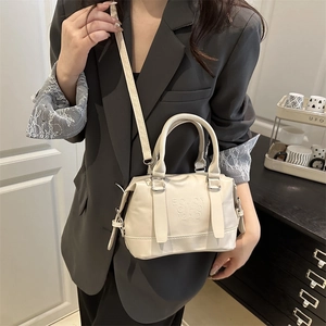 Chic cream leather crossbody pillow bag with letter embossing and top handle for women