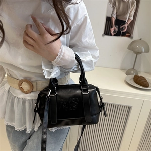 Chic black embossed pillow bag for women with dual handles and adjustable shoulder strap