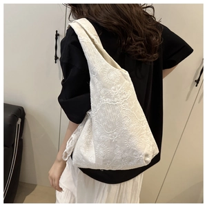 Détail de la broderie en dentelle blanche sur un sac cabas de style coréen minimaliste
