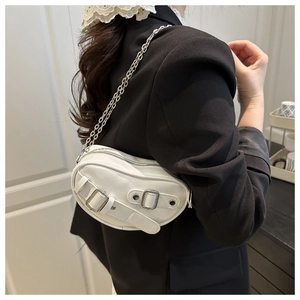 Sac bandoulière blanc en forme de cœur avec boucle argentée porté par un mannequin