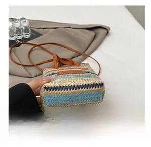 Close-up of the durable reinforced bottom on this colorful striped woven crossbody bag