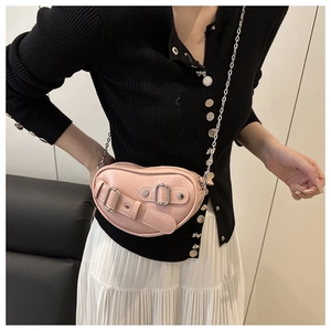 Gros plan détaillé d'un sac bandoulière rose en forme de cœur avec boucle et chaîne
