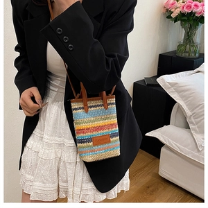 Close-up of colorful striped woven crossbody bag with brown leather fashion tag