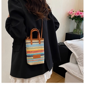 Detail of bohemian rainbow crochet crossbody bag featuring a brown leather strap and tag