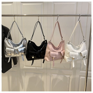 Multiple colors of high-shine underarm bags featuring front buckle pockets and long tassels