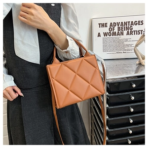 Close-up of caramel brown quilted tote bag with diamond stitching and elegant handle