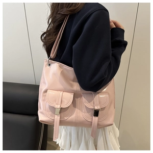 Detail of pink glossy patent leather tote bag with stylish dual front pockets