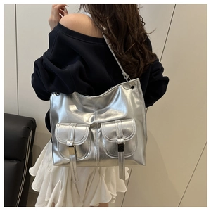 Silver metallic shoulder bag with double front buckle pockets shown on a model