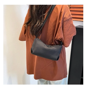 Détail du sac bandoulière noir montrant son tissu en nylon résistant et sa fermeture éclair