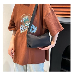 Detailansicht der minimalistischen schwarzen Umhängetasche aus Nylon an einem Model getragen