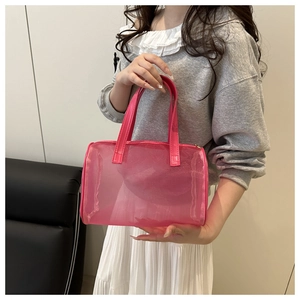 Detail of rose pink mesh handbag with PU leather handles shown in a lifestyle setting