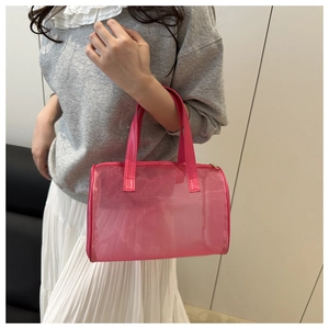 Detail of pink translucent mesh cylinder makeup bag with pink PU handle being carried