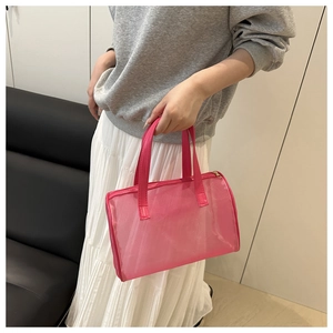 Detail of hot pink mesh handbag with gold zipper and leather handles in a hand-held view