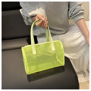 Detail of neon green mesh tote bag showing translucent fabric and leather handle