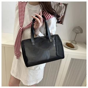 Détail d'un sac à main en résille noire avec anses en cuir dans un cadre intérieur
