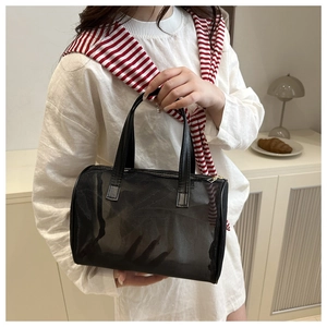 Detail of a portable black mesh vanity bag featuring a leather handle in a lifestyle setting