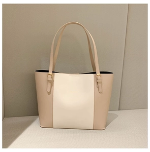 Close-up of contrast color tote bag featuring gold hardware and delicate leather texture
